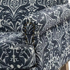 Fauteuil rembourré en bois avec motif floral, accoudoirs à panneaux et dossier en forme de bosse de chameau.